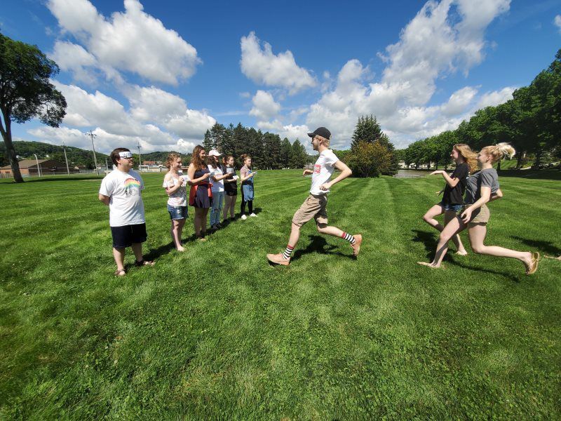 Youth running outside in a grass field.